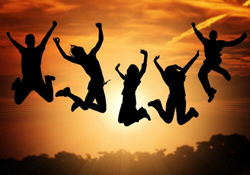 Jugendliche springen vor Sonnenuntergang in die Luft.