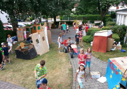 Kinder spielen in einer Kartonstadt.
